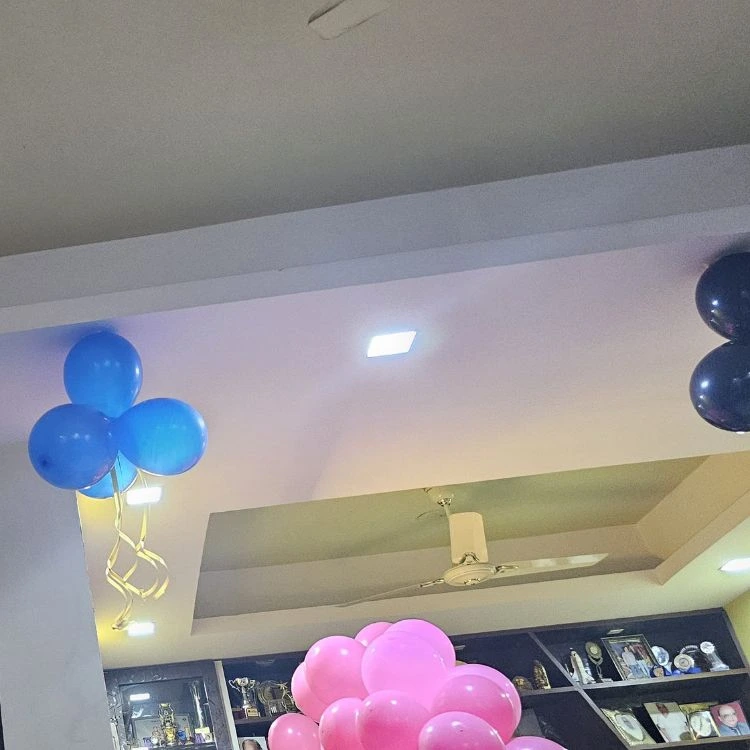 Living room birthday balloon setup with lights and props